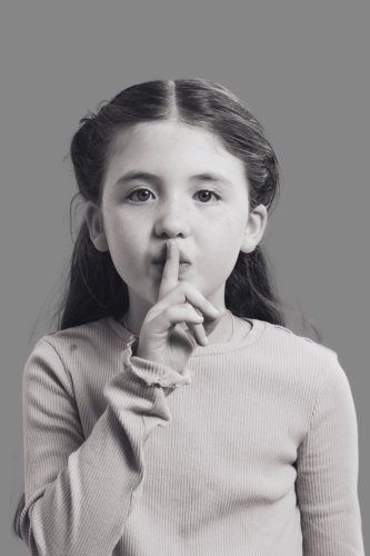 Fotografía echa en un estudio fotográfico de una niña silenciando al espectador